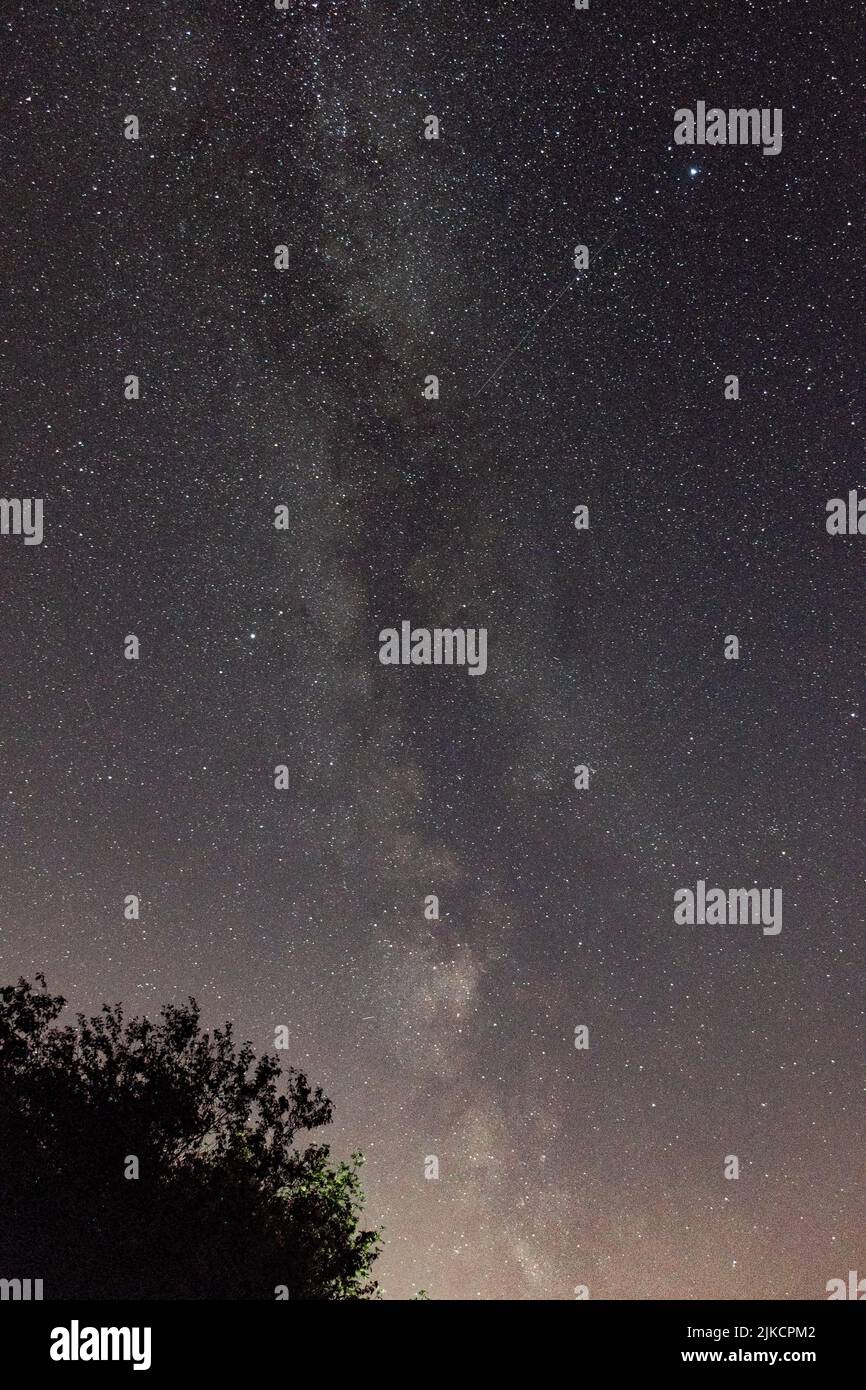 A vertical of Milky Way illuminating the dark night sky Stock Photo - Alamy