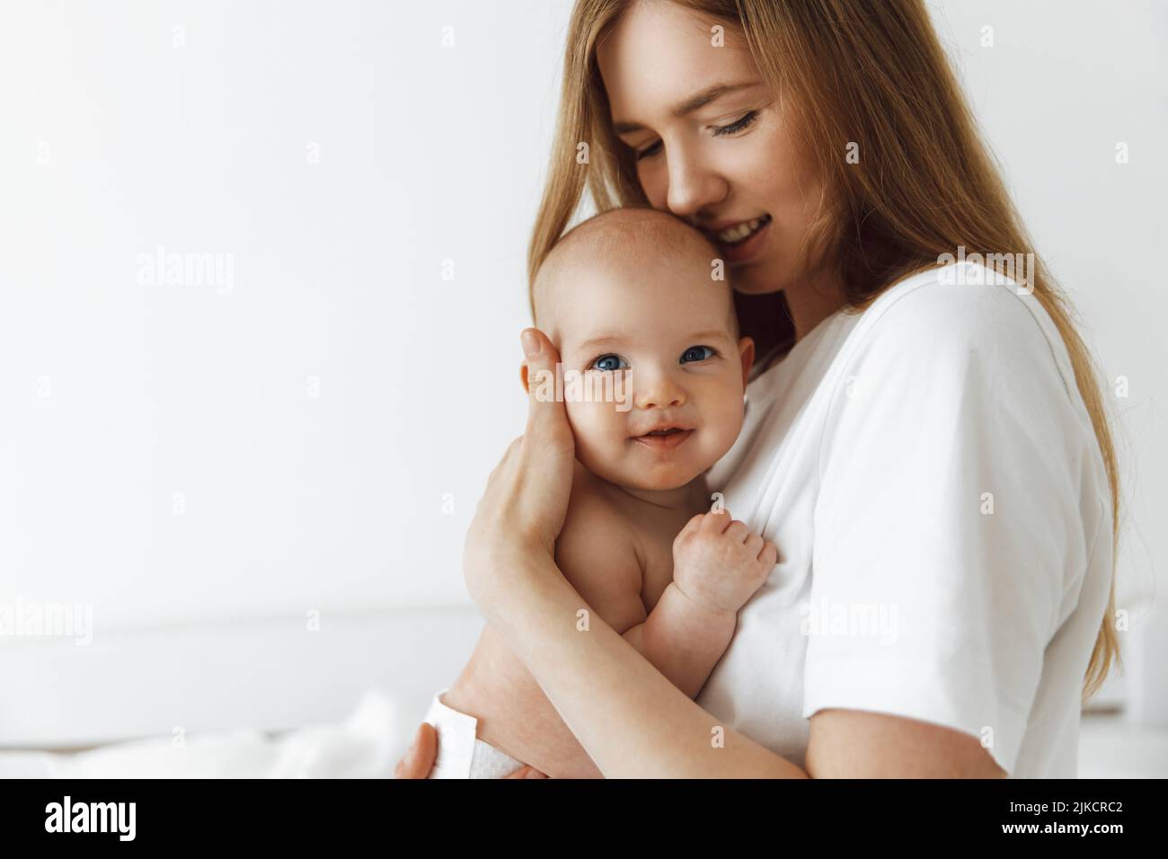 young caring mother hugged her little daughter, pressing her to her ...