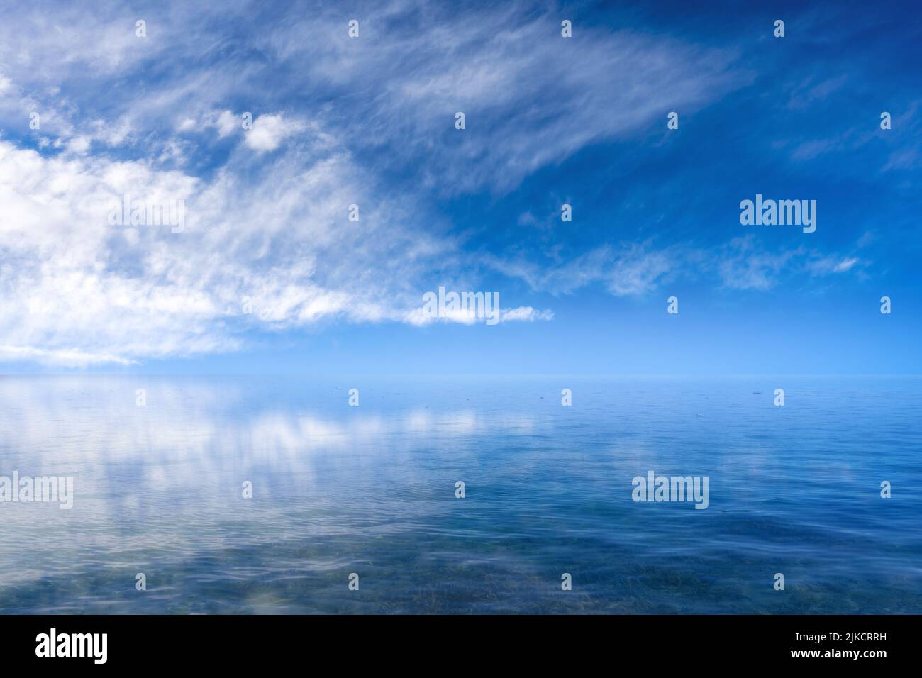 A beautiful shot of a blue cloudy sky reflected on a sea Stock Photo ...