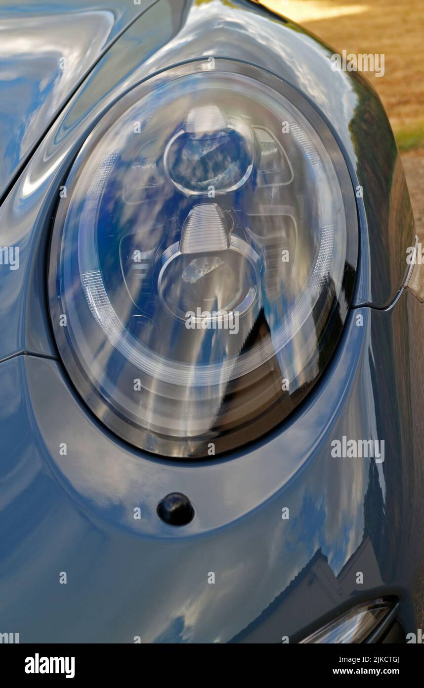 A close-up with detail of a front nearside headlight of a Porsche 911 Carrera GTS. Stock Photo