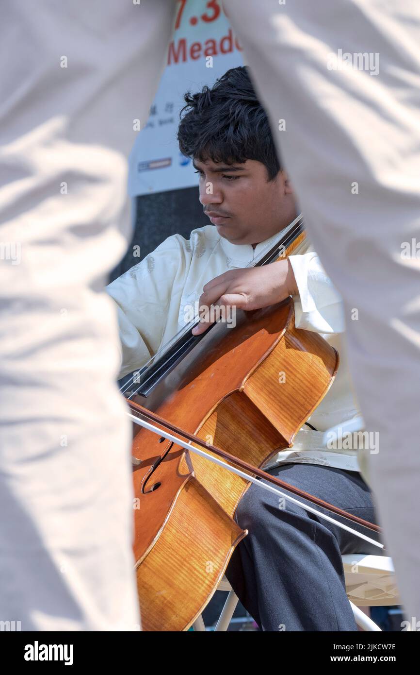 A teenage prodigy & member of the Chinese Music Ensemble of New York plays the cello at the Hong Kong Dragon Boat Festival in Queens, New York. Stock Photo