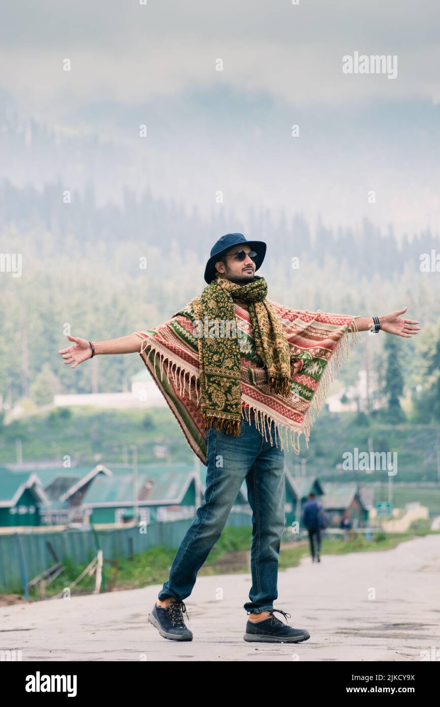 Traveler walking into the horizon on the Ring Road of Gulmarg enjoying the scenery, Jammu and Kashmir, India. Stock Photo