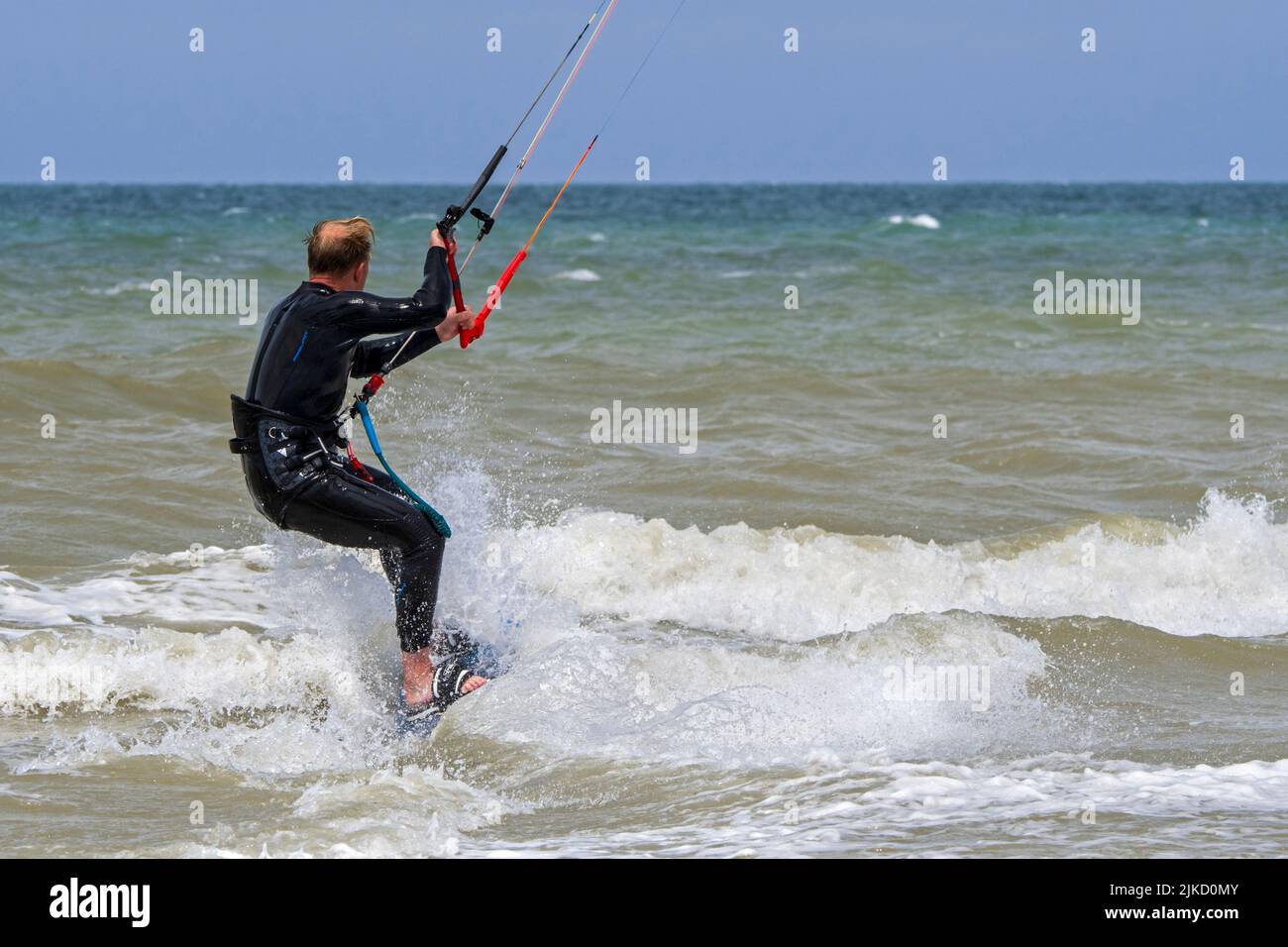 Kiteboarder / kitesurfer wearing wetsuit on twintip board kitesurfing on the North Sea Stock Photo