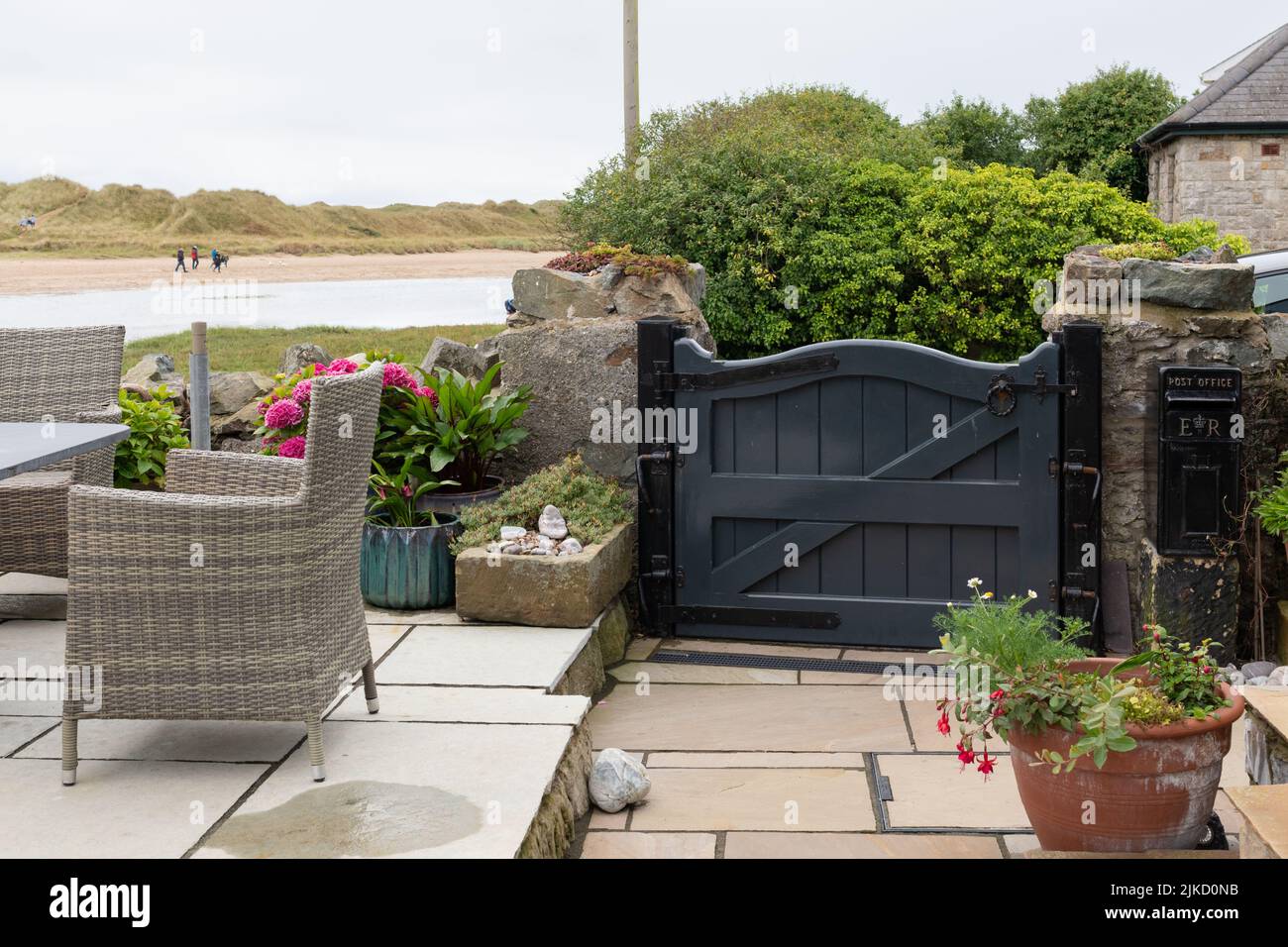 Household flood protection - attractive wooden flood gate barrier protecting garden and property by side of estuary from flooding - UK Stock Photo