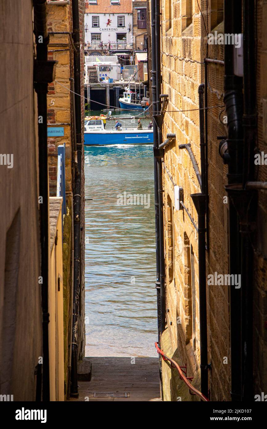 A narrow street leading to the sea in Whitby, a popular holiday destination in Yorkshire Stock Photo
