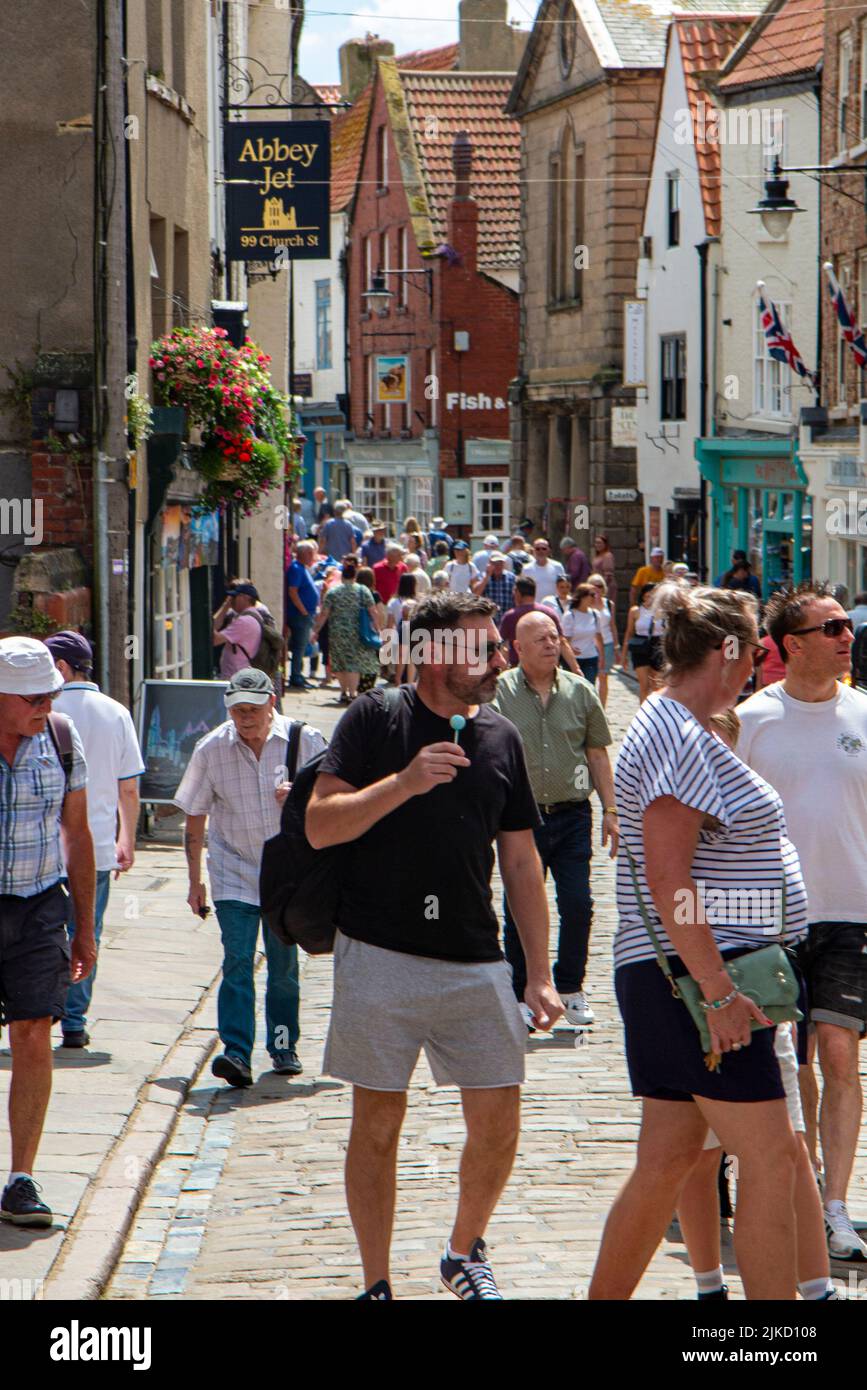 High summer in Whitby and crowds gather in the shopping streets Stock Photo