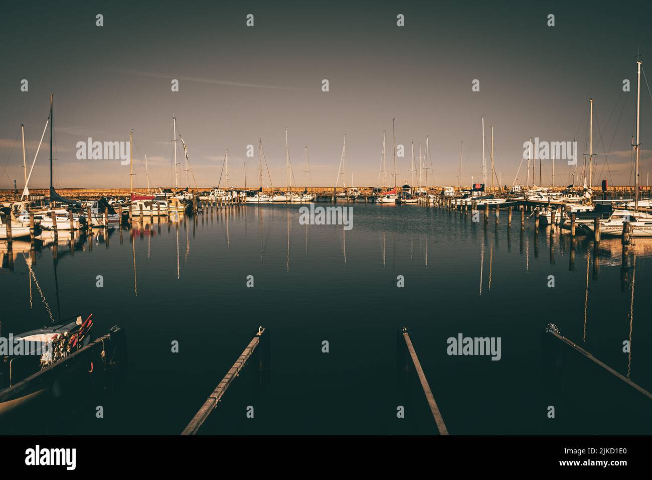 A port with boats reflected in the water Stock Photo - Alamy