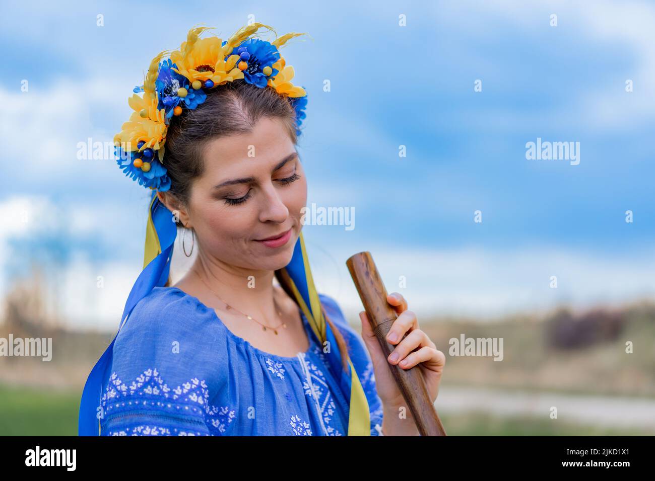 Woman playing woodwind wooden flute ukrainian sopilka outdoors. Folk