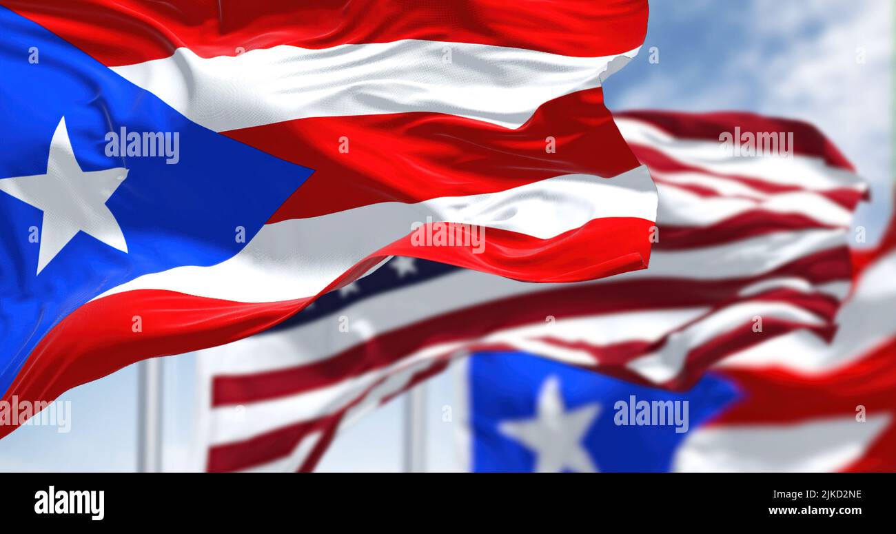 Flags of Puerto Rico waving in the wind with the United States flag on a clear day. Puerto Rico is a Caribbean island and unincorporated territory of Stock Photo