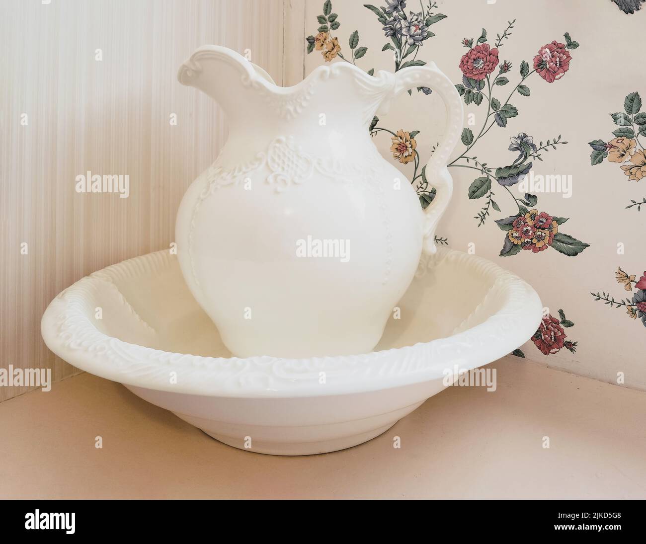 Vintage ivory bowl and pitcher with retro wallpaper background Stock Photo
