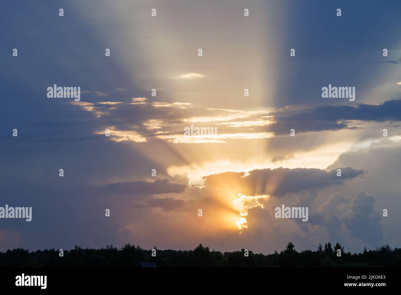 cloudy sunset sky with yellow sun rays with horizon Stock Photo