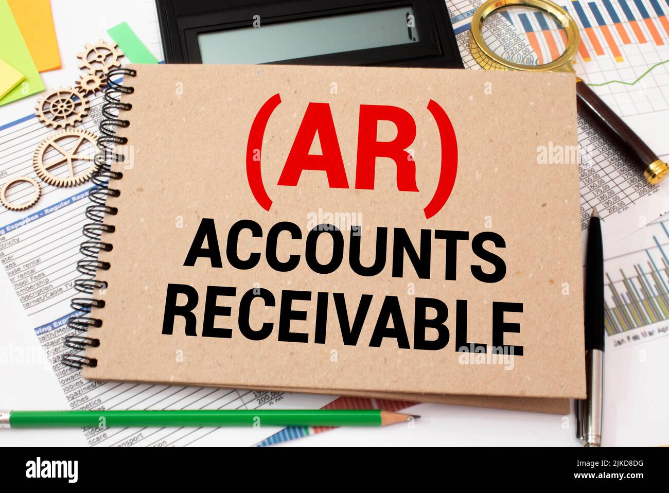 Open book with figures and paper with words accounts receivable Stock