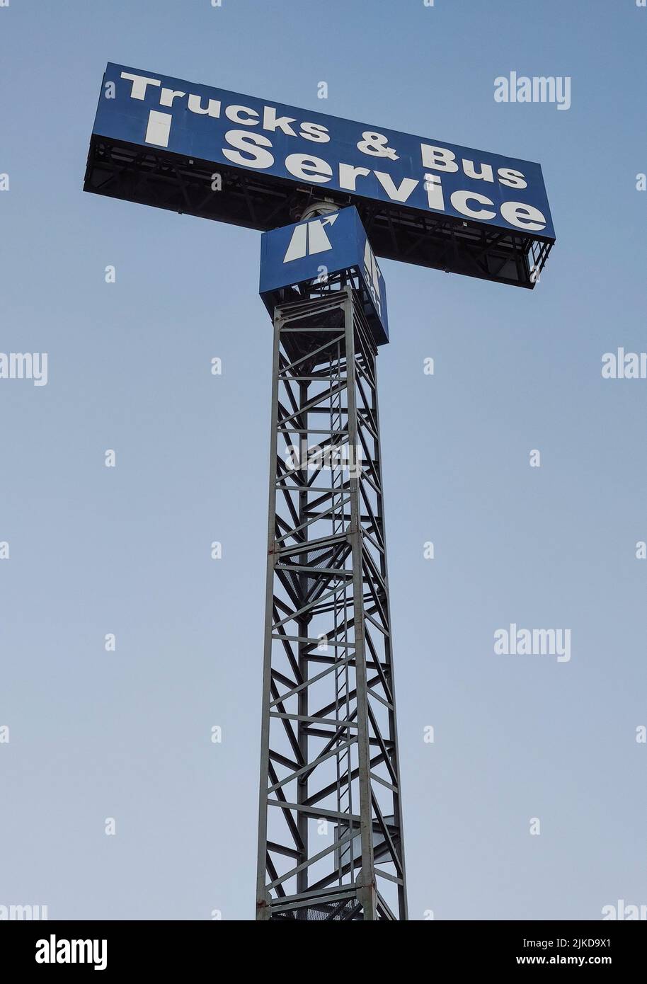 Trucks and bus service sign pole over blue sky. Stock Photo