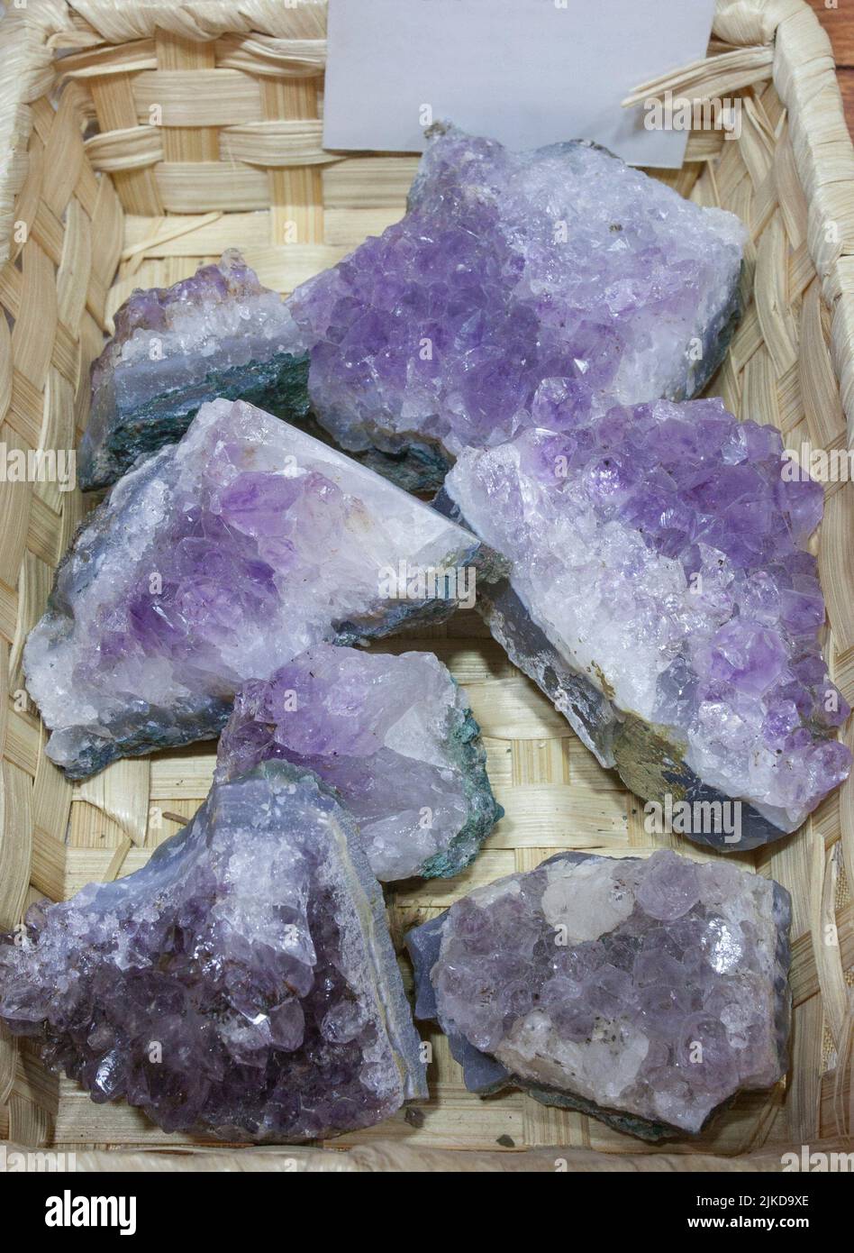 Amethyst Fragments, believed to have beneficial health properties. Displayed on basket at street market stall. Stock Photo