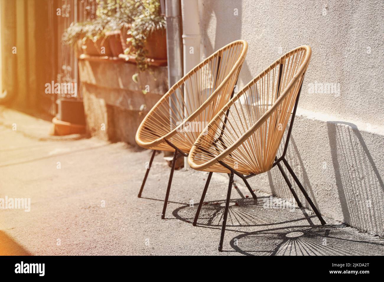 Rattan Wicker Chair. Wicker Armchairs Stand Outside. Modern Furniture At Street. Cafe Furniture. Trendy Designer Chairs. Fashion Designer Armchairs. Stock Photo