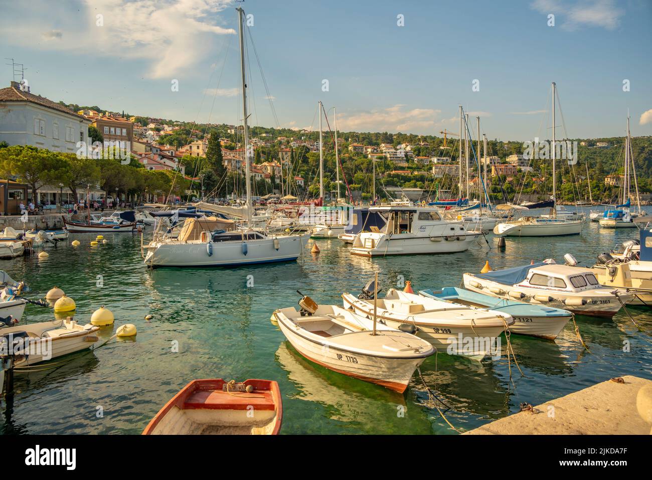 View of boats in the marina and harbourside restaurants during golden hour in Volosko, Opatija, Croatia, Europe Stock Photo