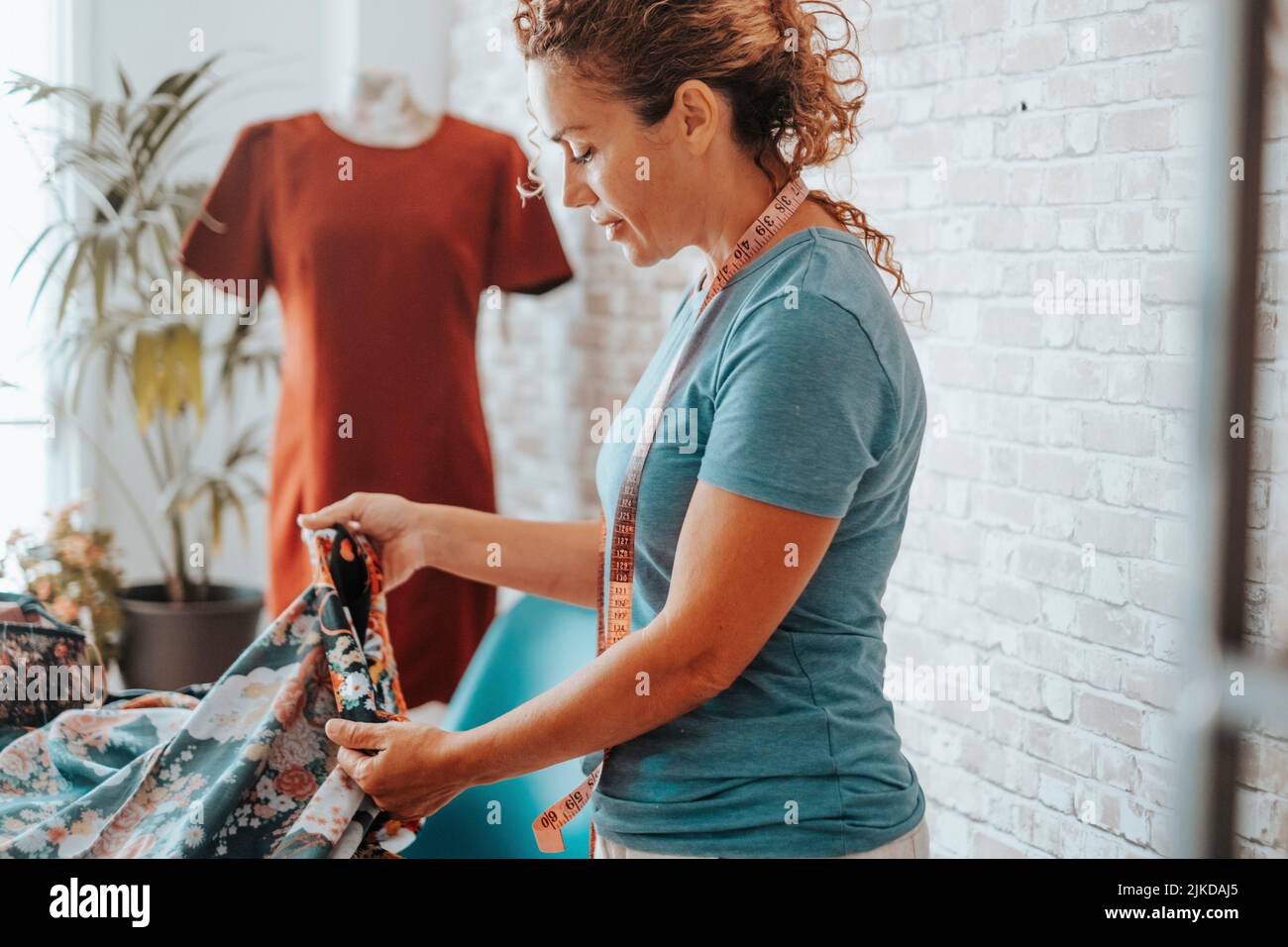 Woman in tailor activity at home or design studio store. of