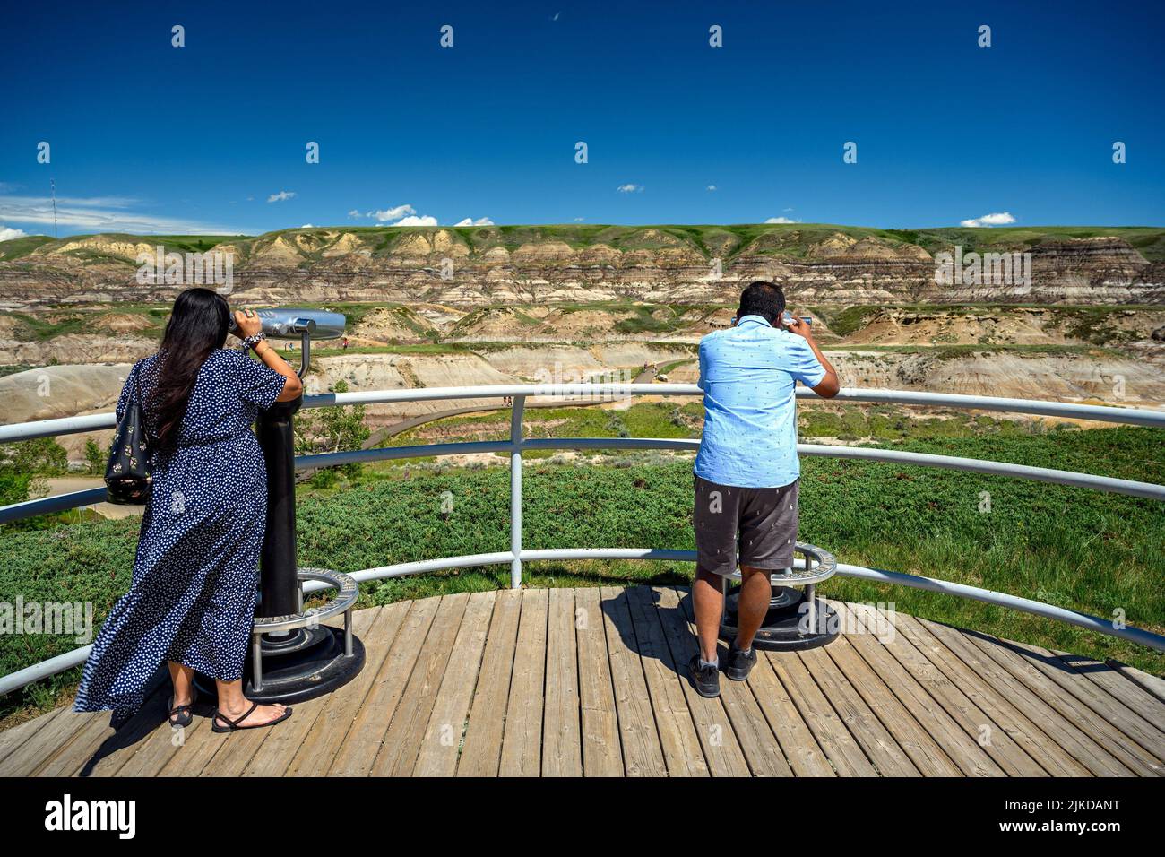 Tourists observing the landscape of the Canadian Badlands via binocular in Drumheller, the dinosaur capital of the world, Alberta, Canada. Stock Photo