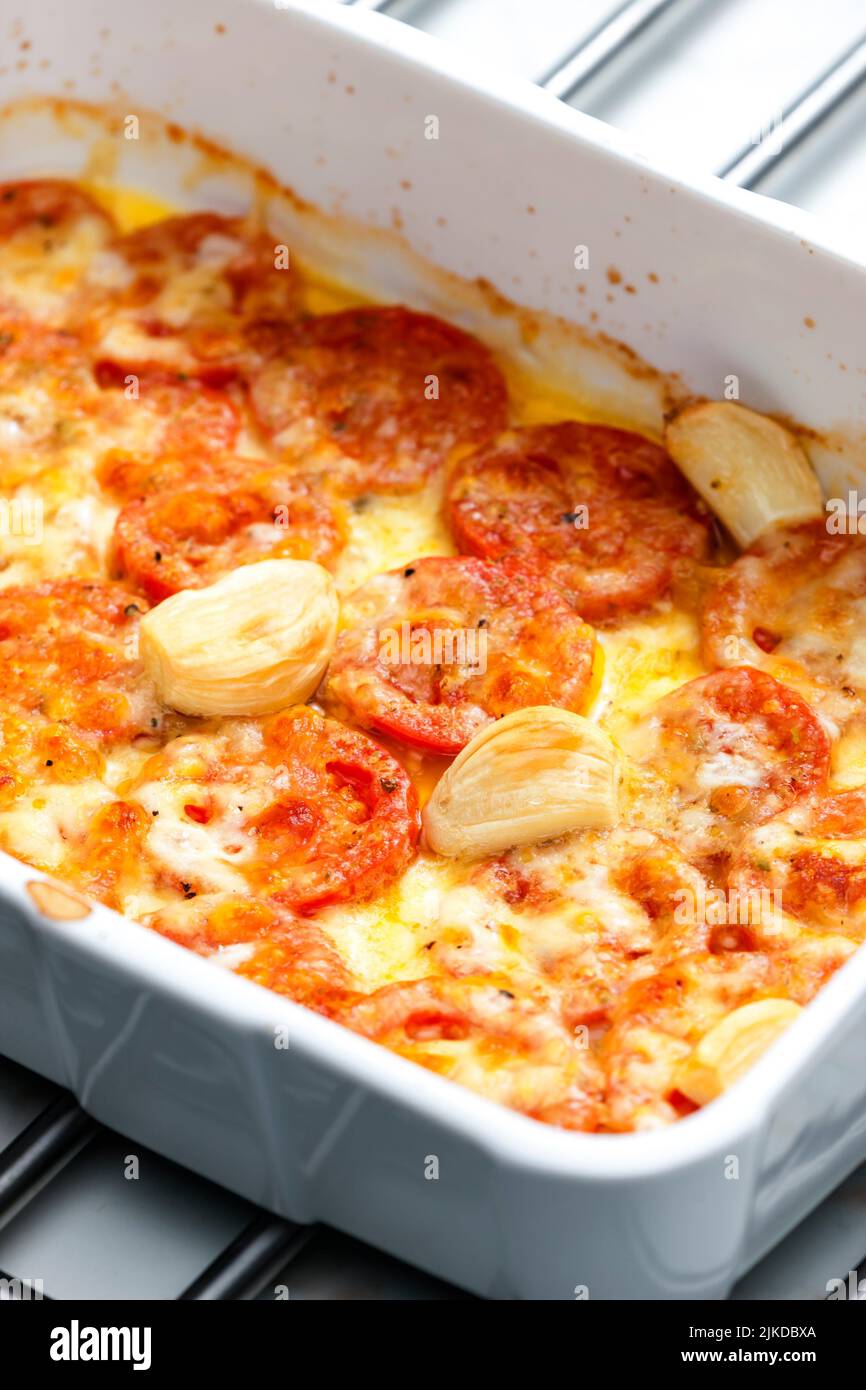 baked tomatoes with cheese and garlic. Stock Photo