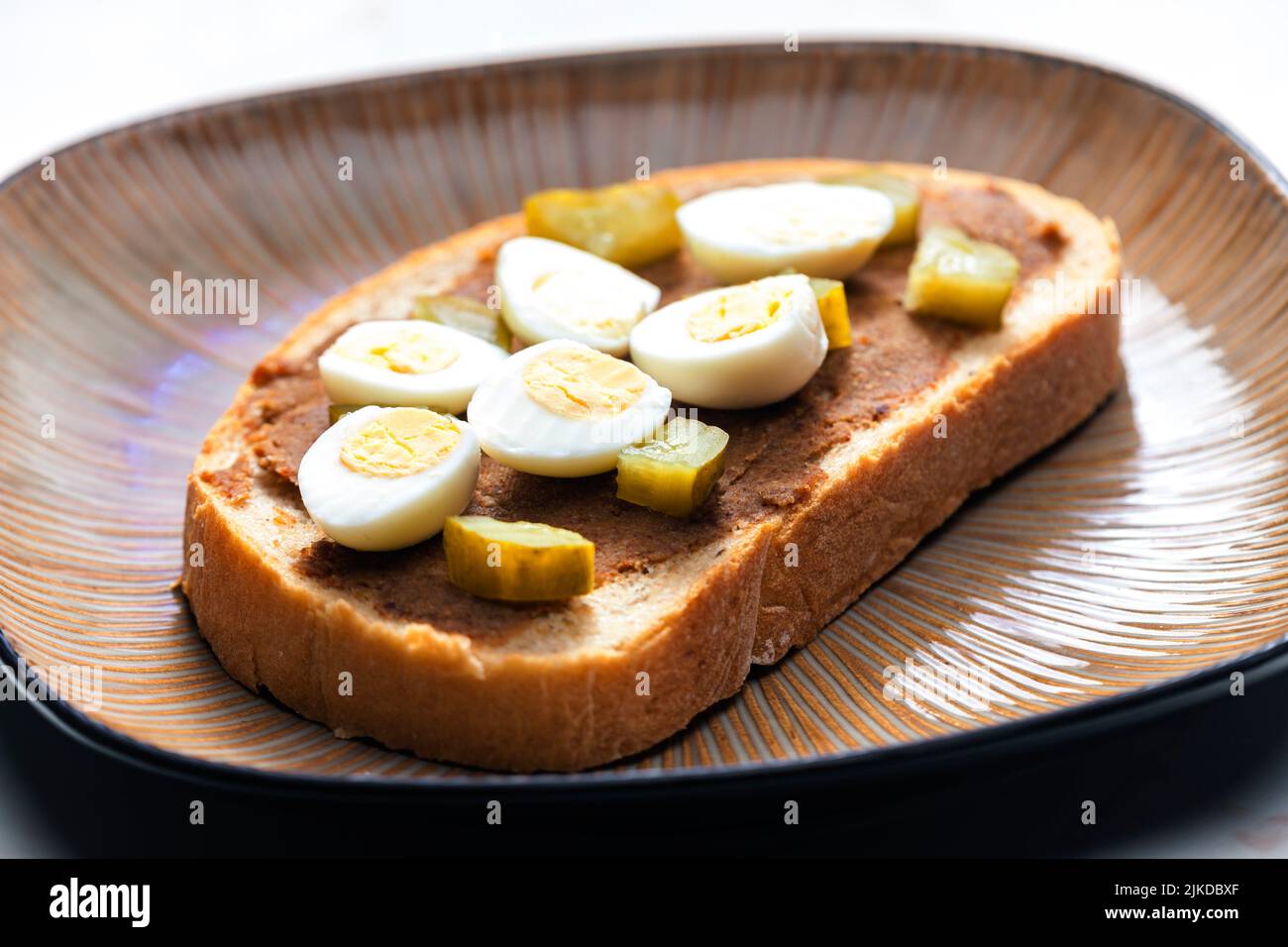 cracklings spread with pickled cucumber and boiled egg on slice of bread. Stock Photo
