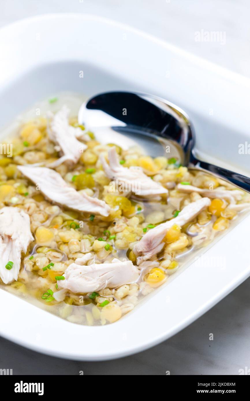 broth with chicken meat, barley groats and yellow peas. Stock Photo