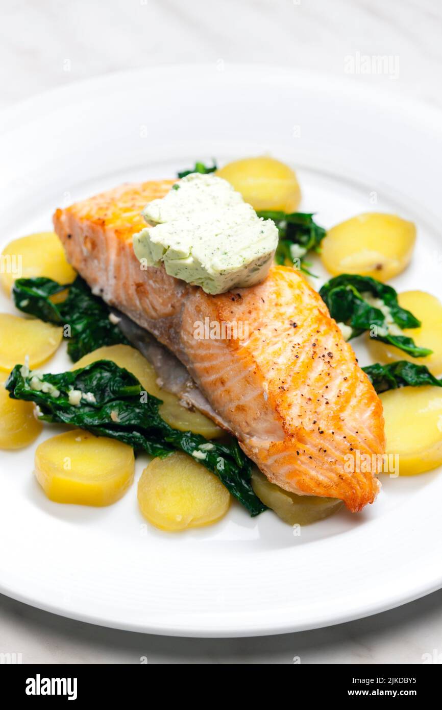 baked salmon with spinach leaves and potatoes. Stock Photo