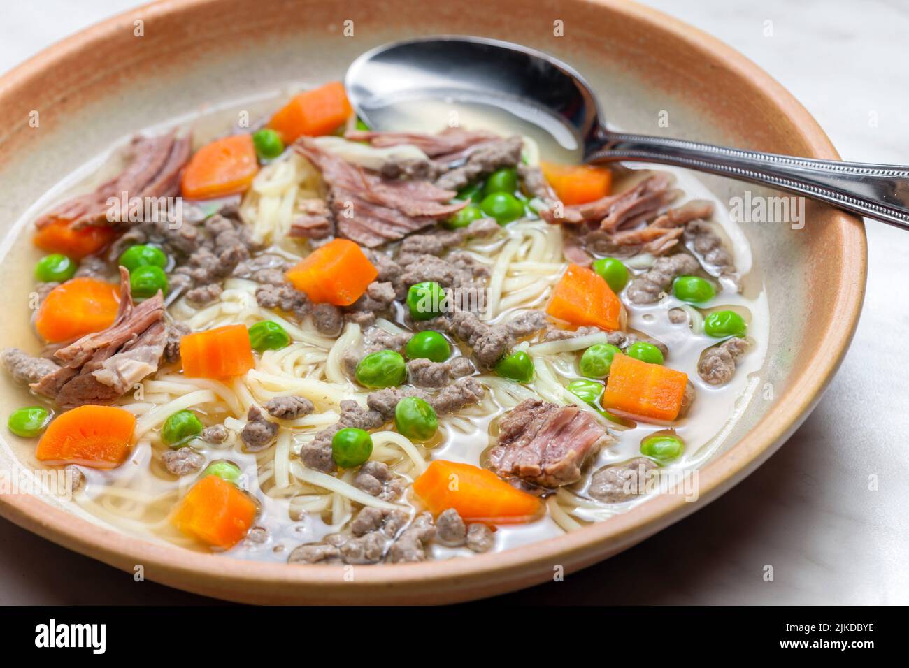 beef broth with green peas, carrot and small meatballs. Stock Photo