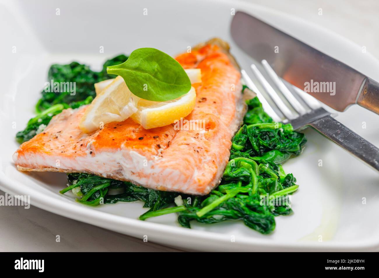 grilled salmon fillet with spinach leaves salad. Stock Photo