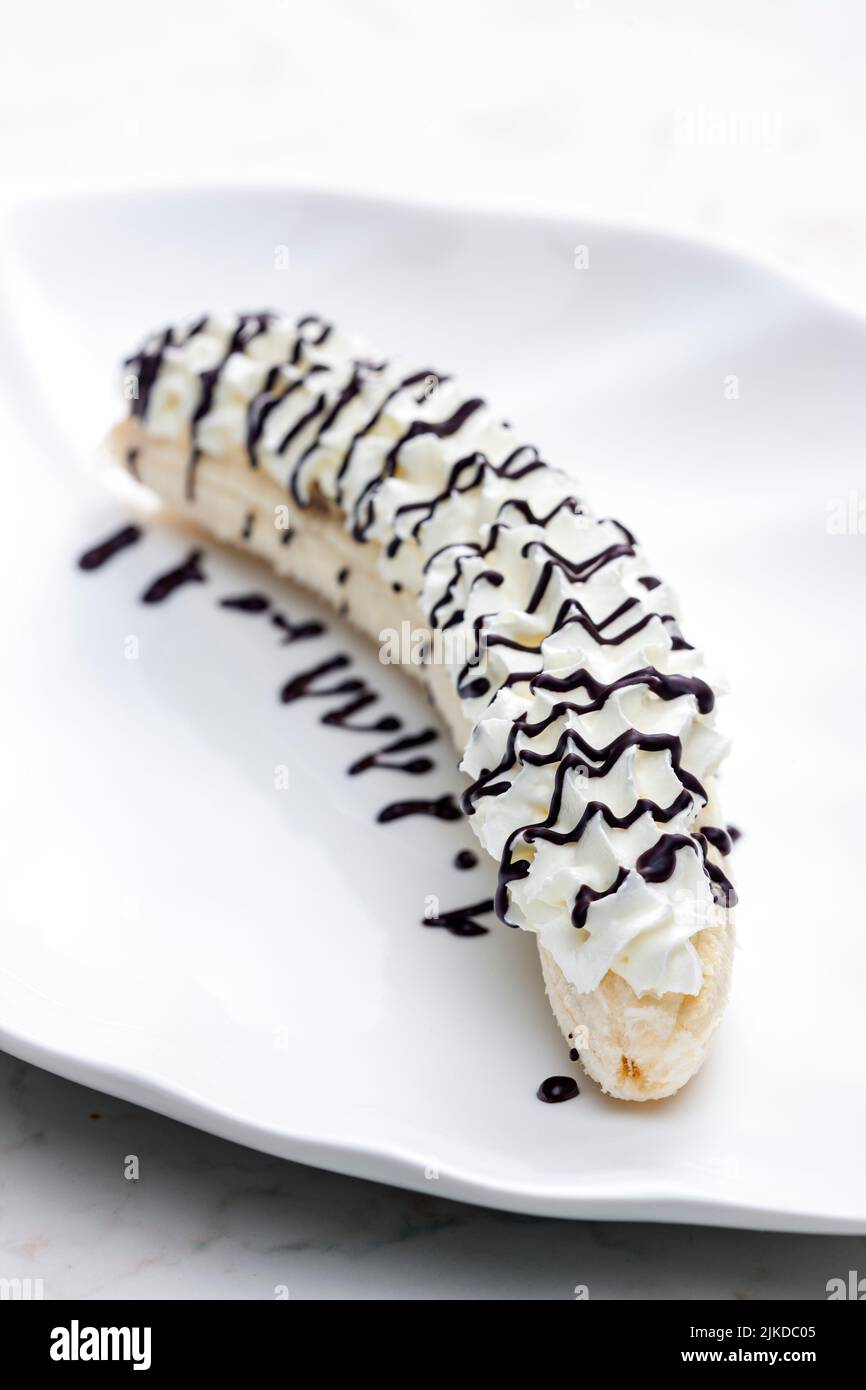 banana with whipped cream and chocolate topping. Stock Photo