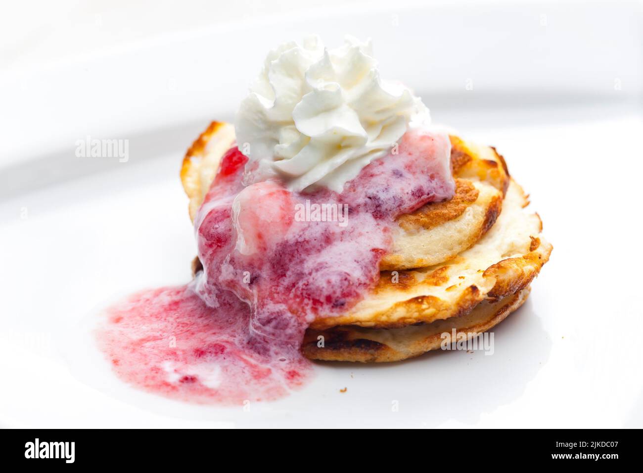 pancakes with fruit sauce and whipped cream. Stock Photo