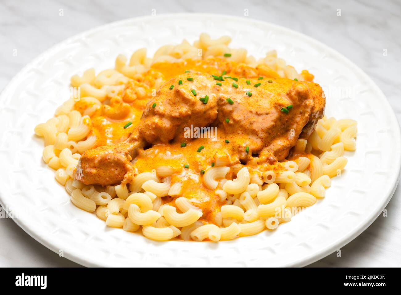 chicken leg with paprika creamy sauce with pasta. Stock Photo