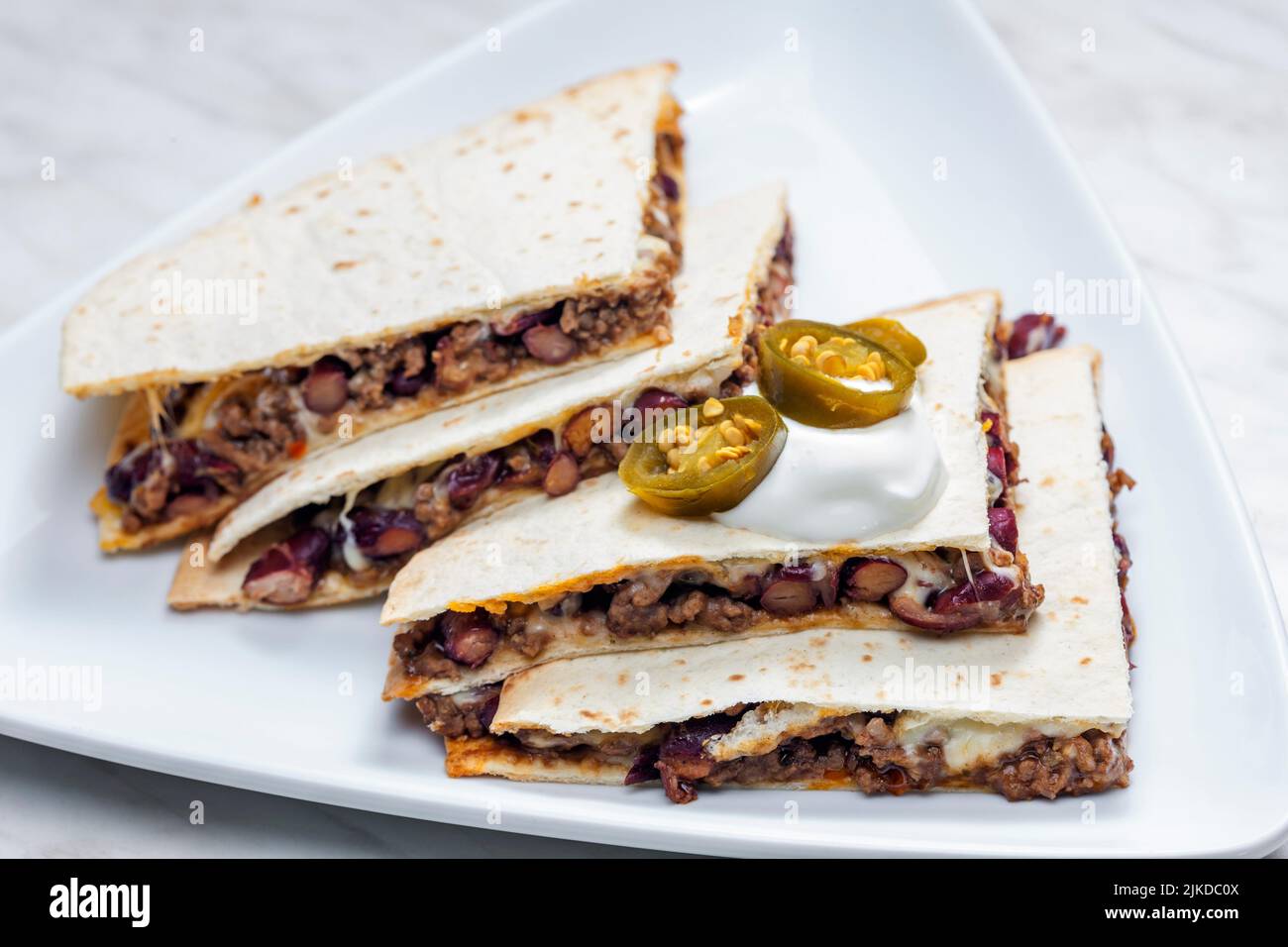 quesadilla filled with minced beef meat, beans and cheese. Stock Photo