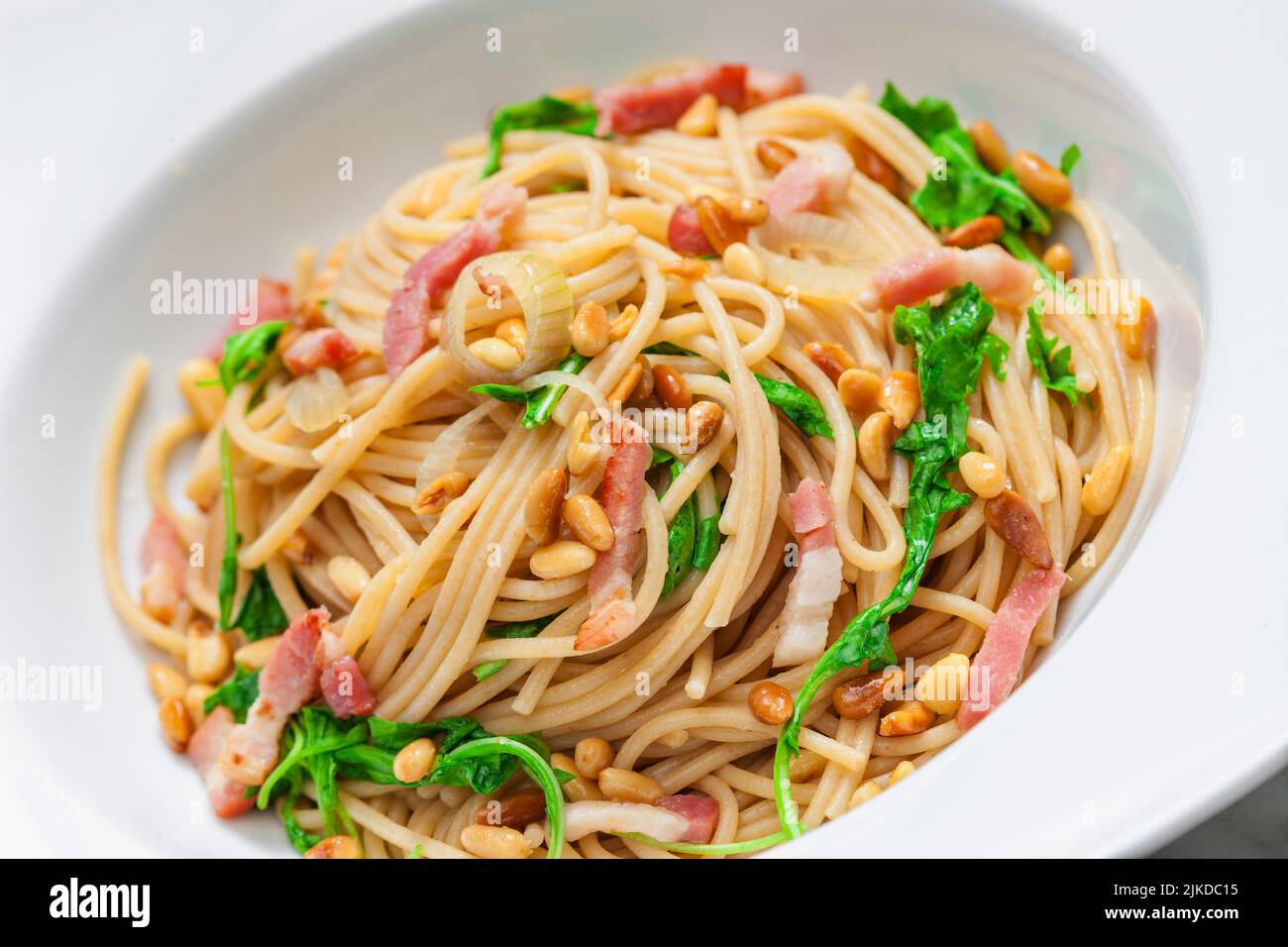 spaghetti with spinach, bacon and kernels. Stock Photo