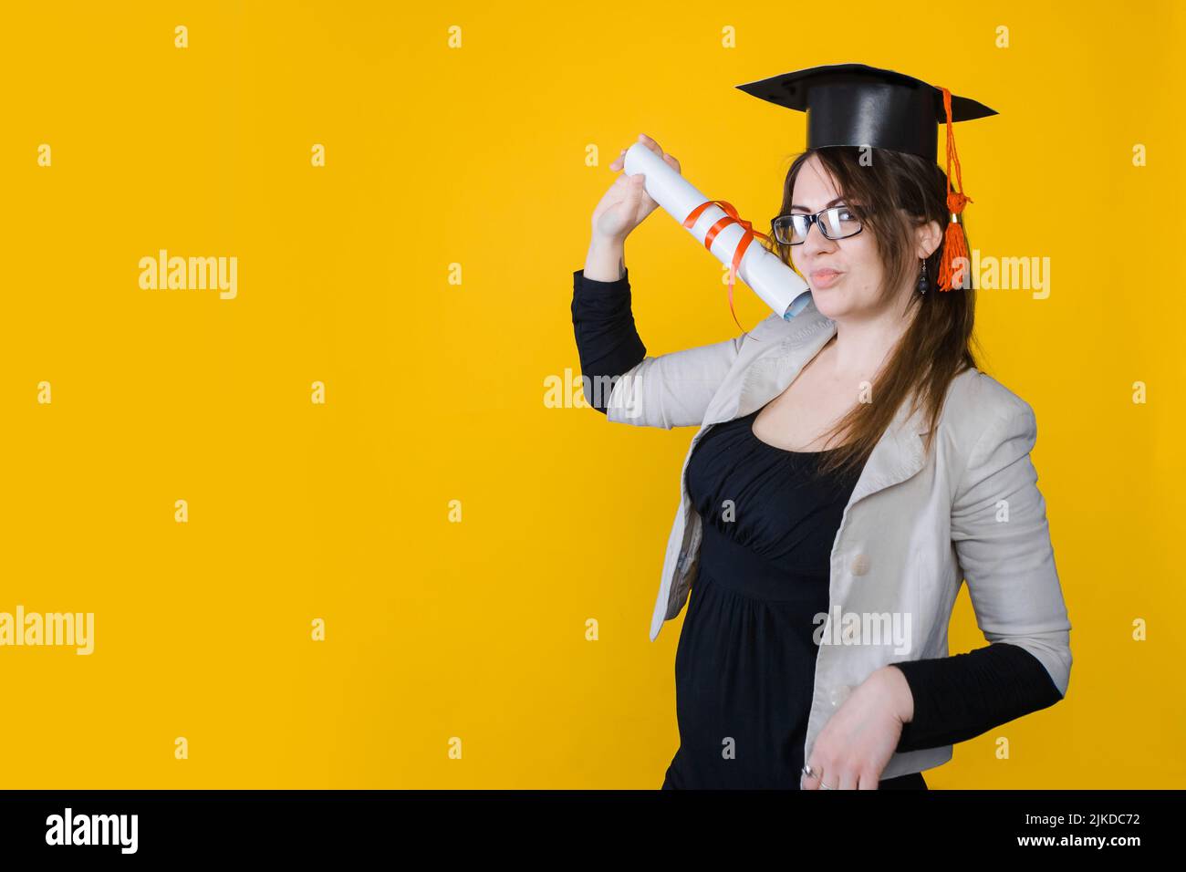 Portrait of graduate girl on bright yellow background, copy space Stock ...