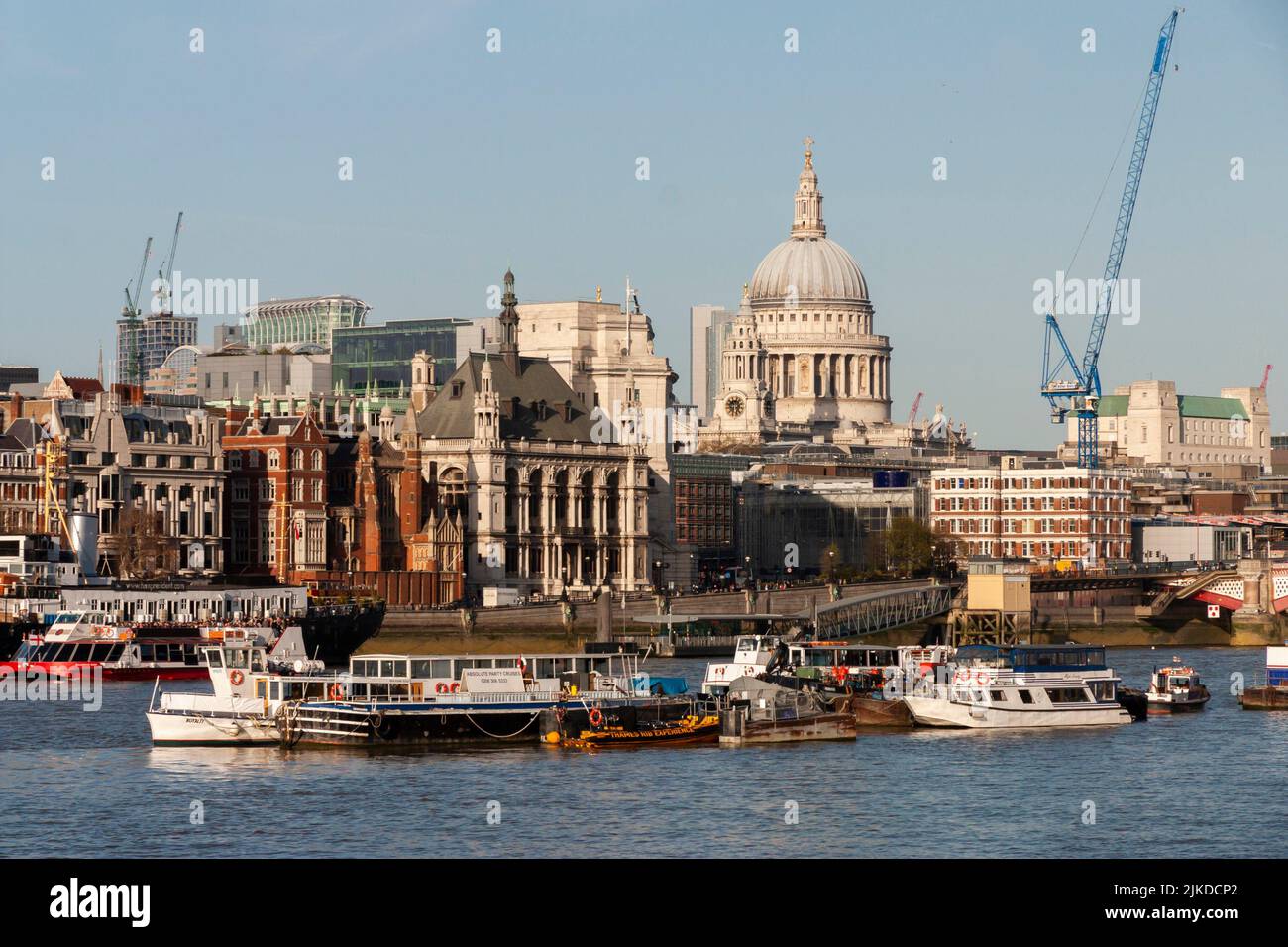 London, England - Aril 1, 2012: The River Thames with ships and boats and the city of london with St. Paul's Cathedral and buildings. Stock Photo