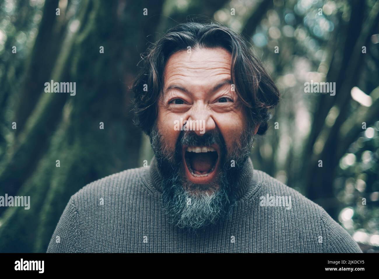Mad mature man shouting crazy at the camera. Stressed people portrait concept life. Bearded young senior man shout with craziness and open mouth. Stock Photo