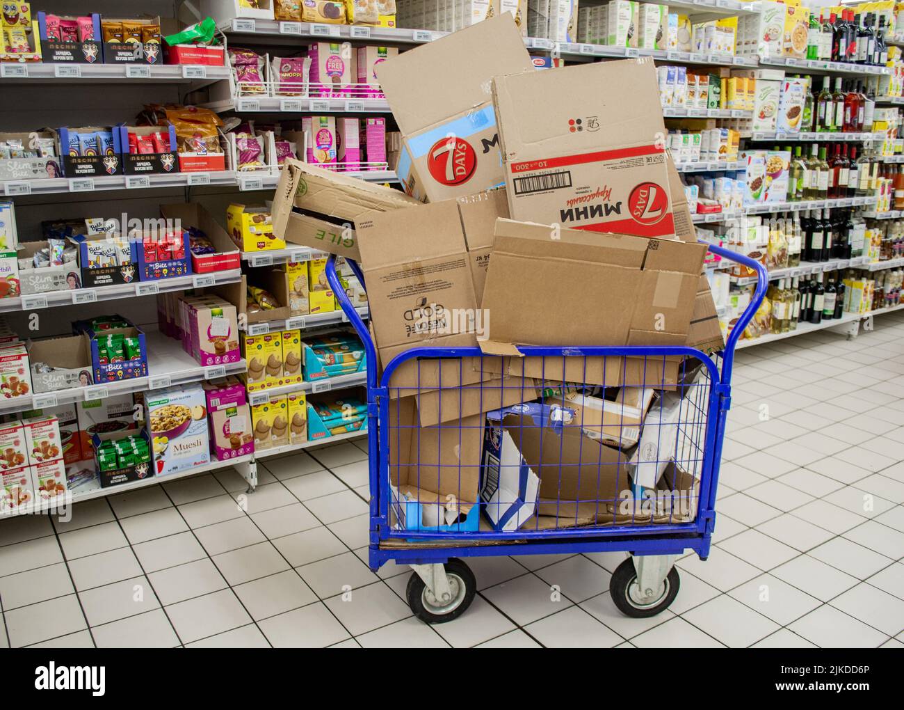 Moscow, Russia, September 2019: a Huge cargo cart with a bunch of empty cardboard boxes of goods in a supermarket on the background of a row with prod Stock Photo