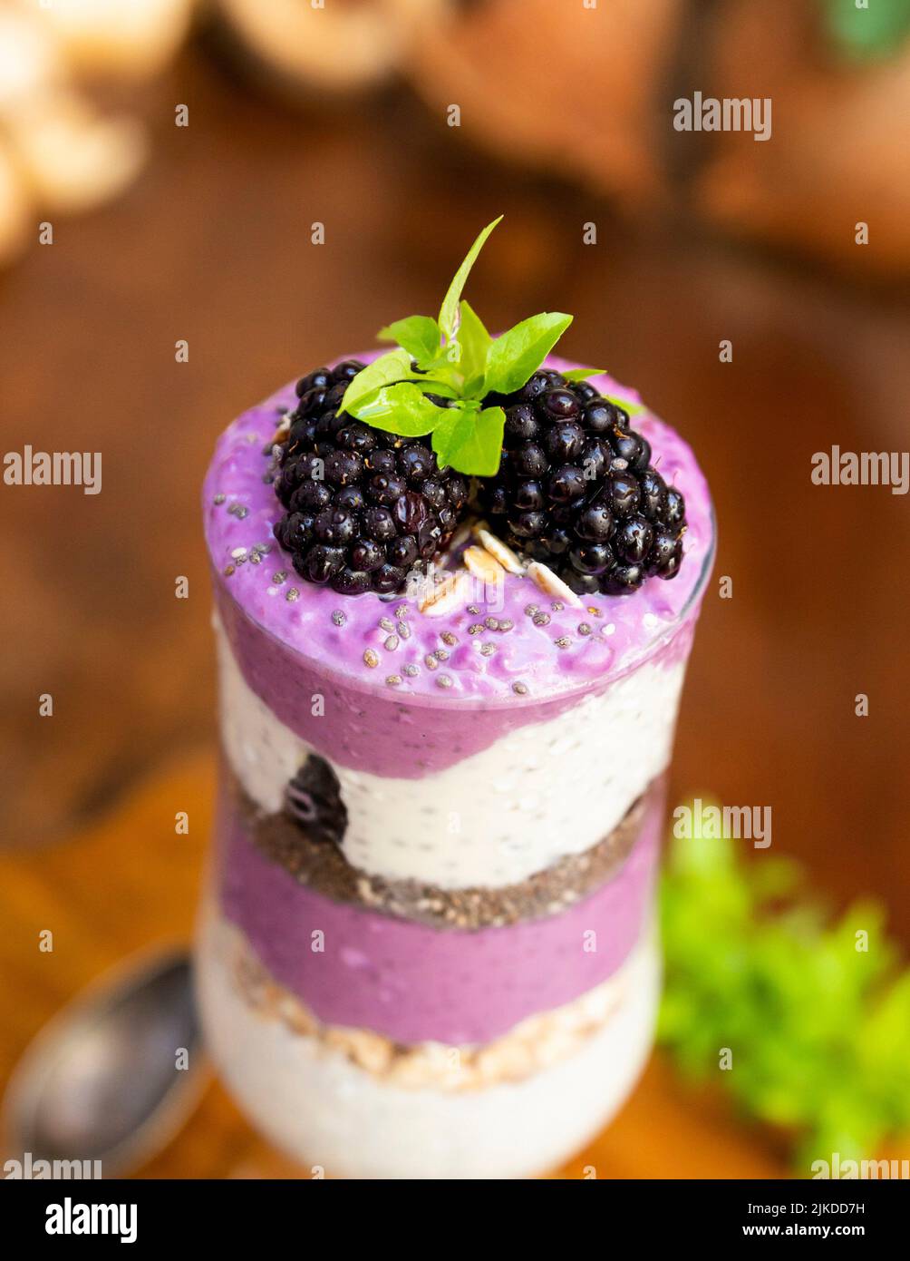 Blackberry smoothies with chia seeds in glass with fresh berries and mint on rustic wooden table. Stock Photo