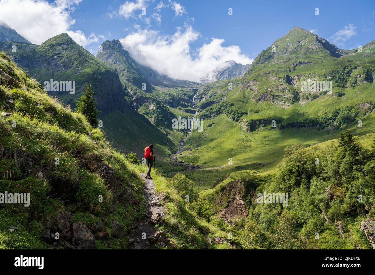 hiker observing the top, Ascending towards Hourgade Peak, Pyrenean mountain range, France. Stock Photo