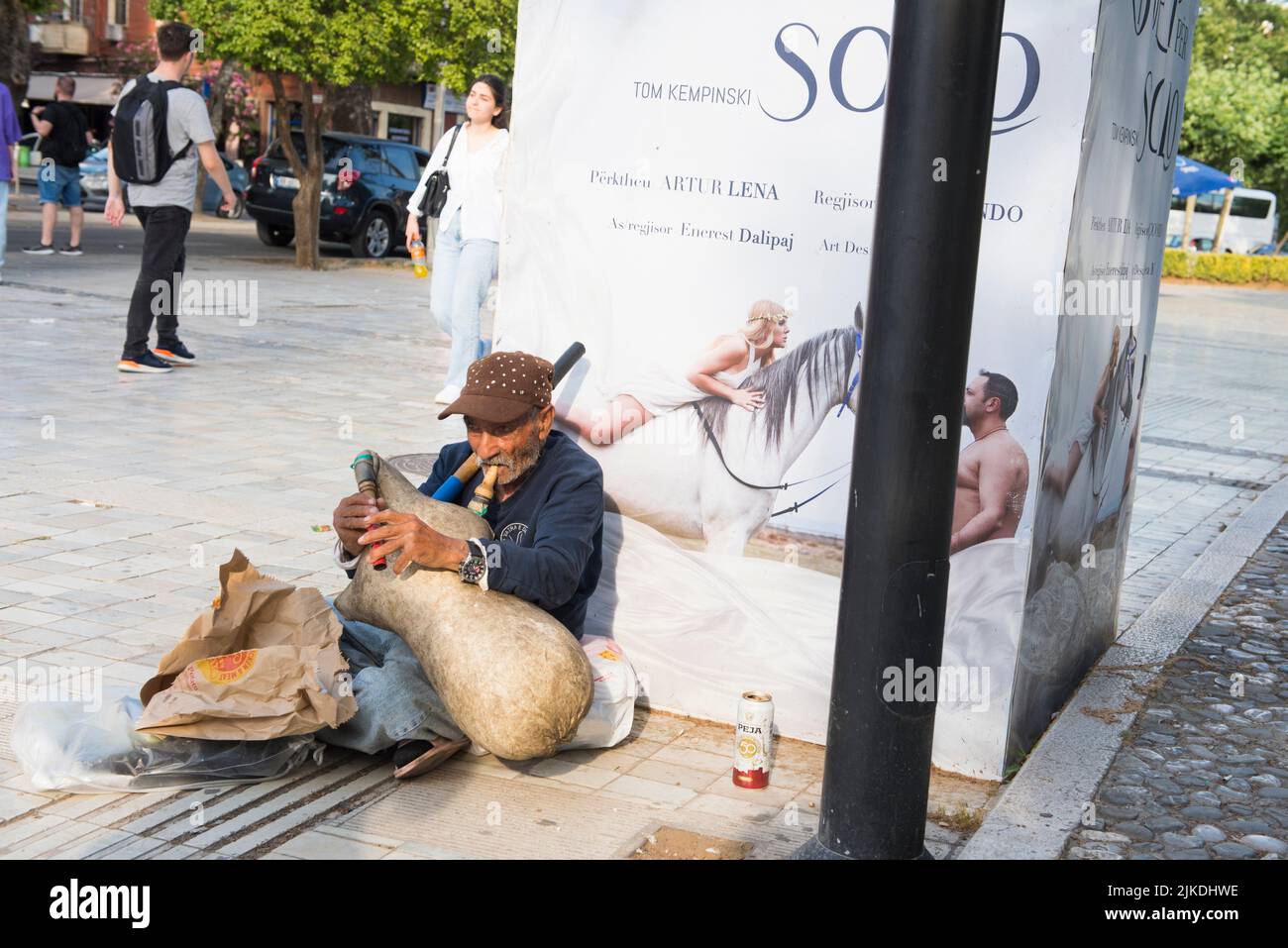 Old man begging by playing some kind of bagpipe in a street of Tirana, Albania, Southeastern Europe. Stock Photo