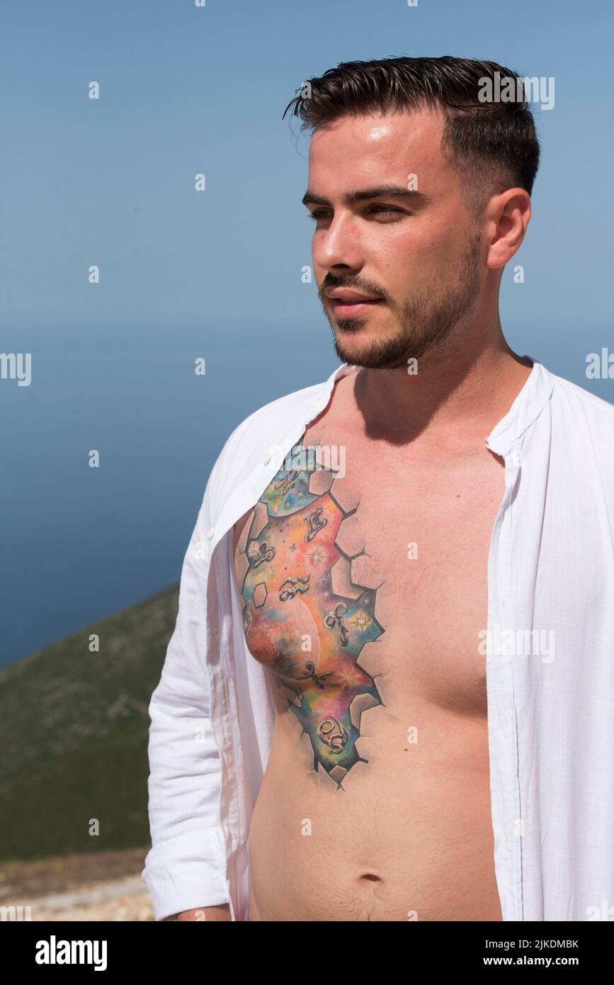 Young man with a tattoo on his chest representing a personal map of Albania, Llogara National Park, a national park centered on the Ceraunian Stock Photo