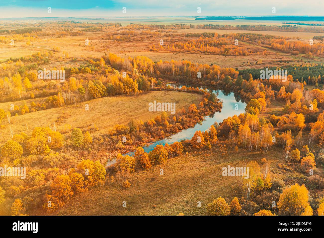 Aerial view yellow forest and curved river landscape in sunny autumn day. Top view of beautiful european nature from high attitude in autumn season Stock Photo