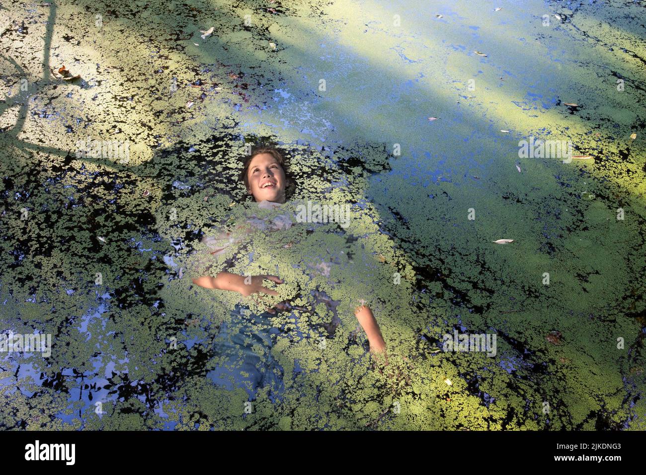 Photo montage of a girl semi immersed in water of a small pond covered with water lenses, Eure-et-Loir department, Centre-Val-de-Loire region, Stock Photo