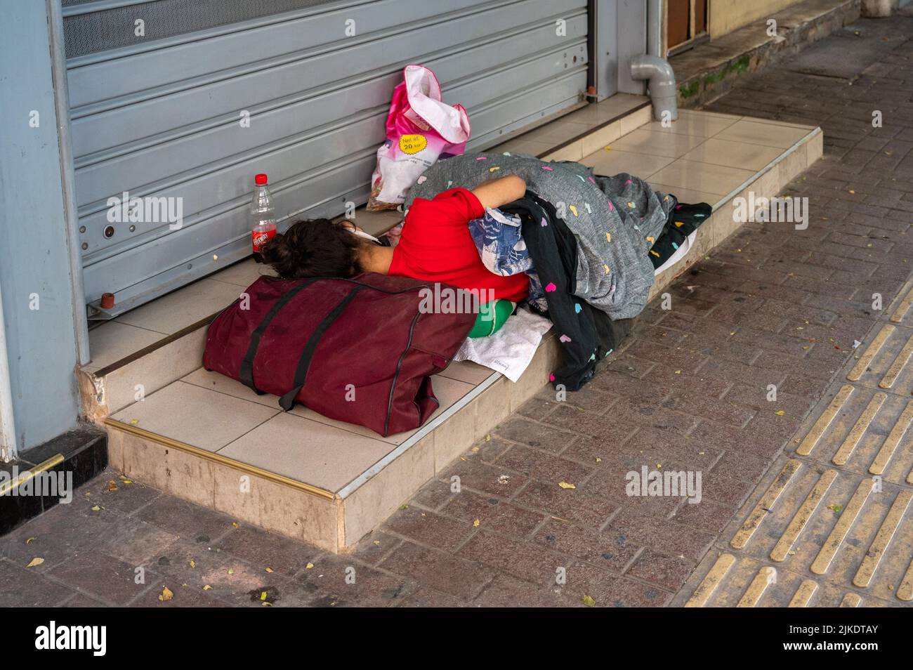 ATHENS, GREECE - MAY 14, 2022: A homeless man sleeps on a sidewalk in ...
