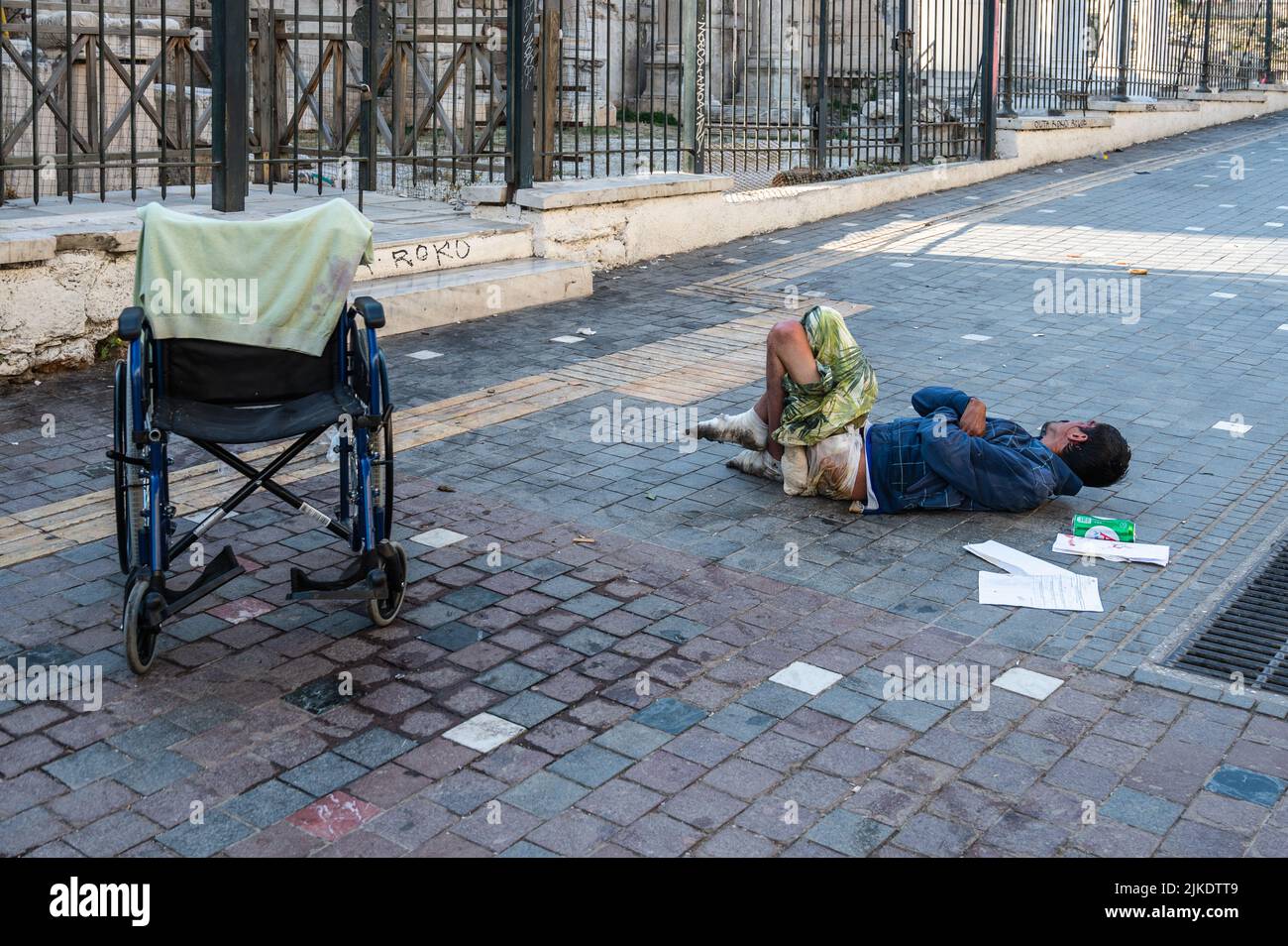 ATHENS, GREECE - MAY 14, 2022: A homeless man sleeps on a sidewalk in ...