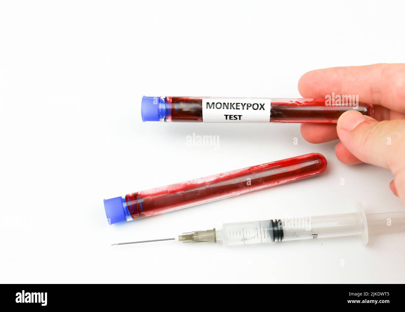Hand holding Test tube filled with blood for testing and syringe with ...
