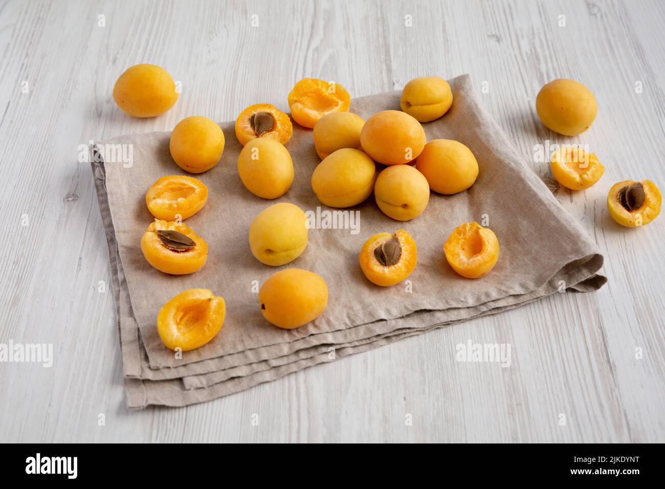 Raw White Apricot Angelcots on a white wooden background, side view. Stock Photo