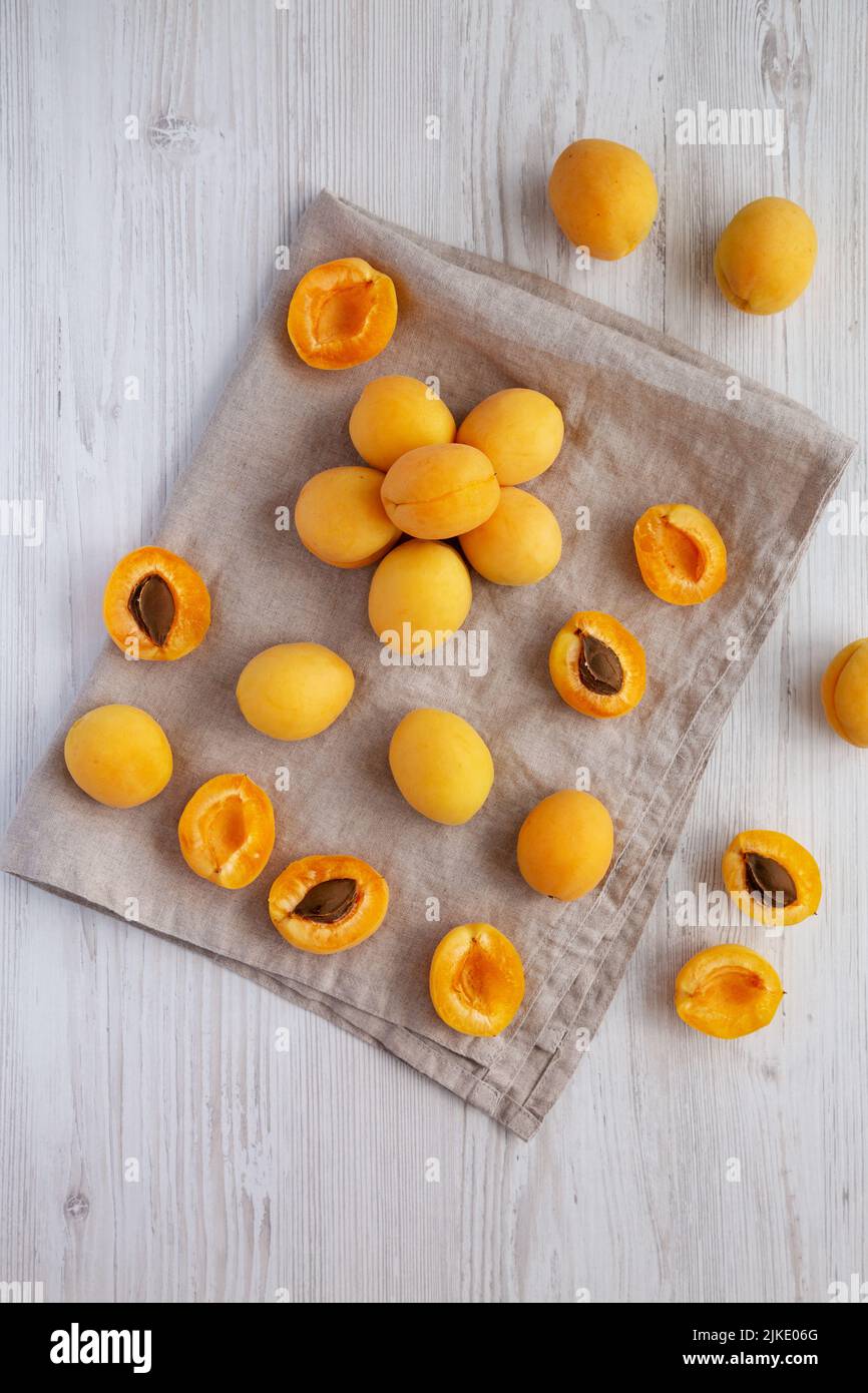 Raw White Apricot Angelcots on a white wooden background, top view. Flat lay, overhead, from above. Stock Photo