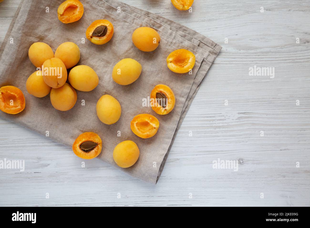 Raw White Apricot Angelcots on a white wooden background, top view. Flat lay, overhead, from above. Copy space. Stock Photo