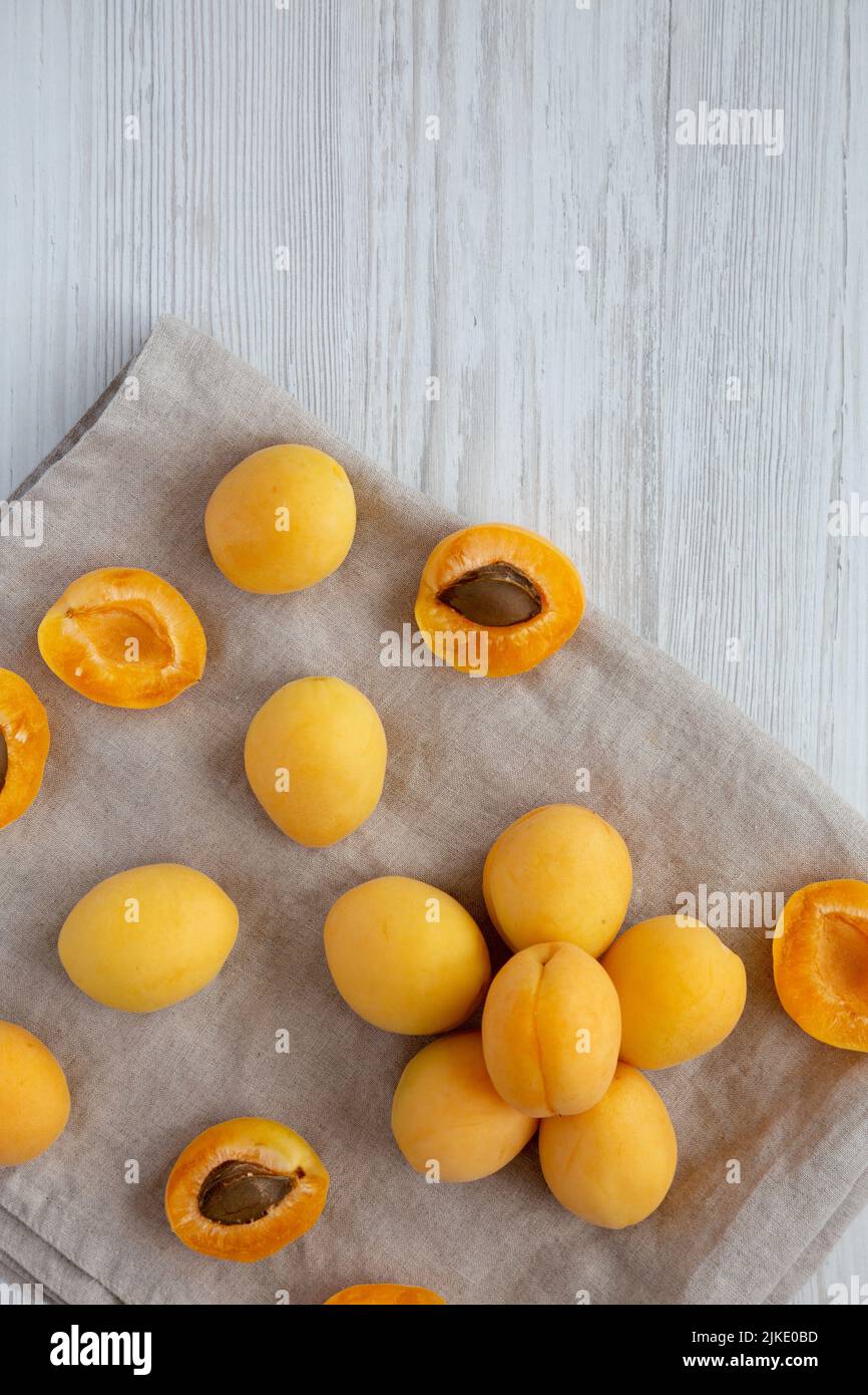 Raw White Apricot Angelcots on a white wooden surface, top view. Flat lay, overhead, from above. Copy space. Stock Photo